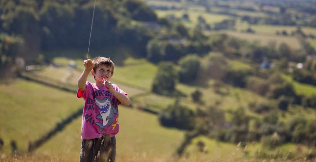A boy flying a kite in the countryside