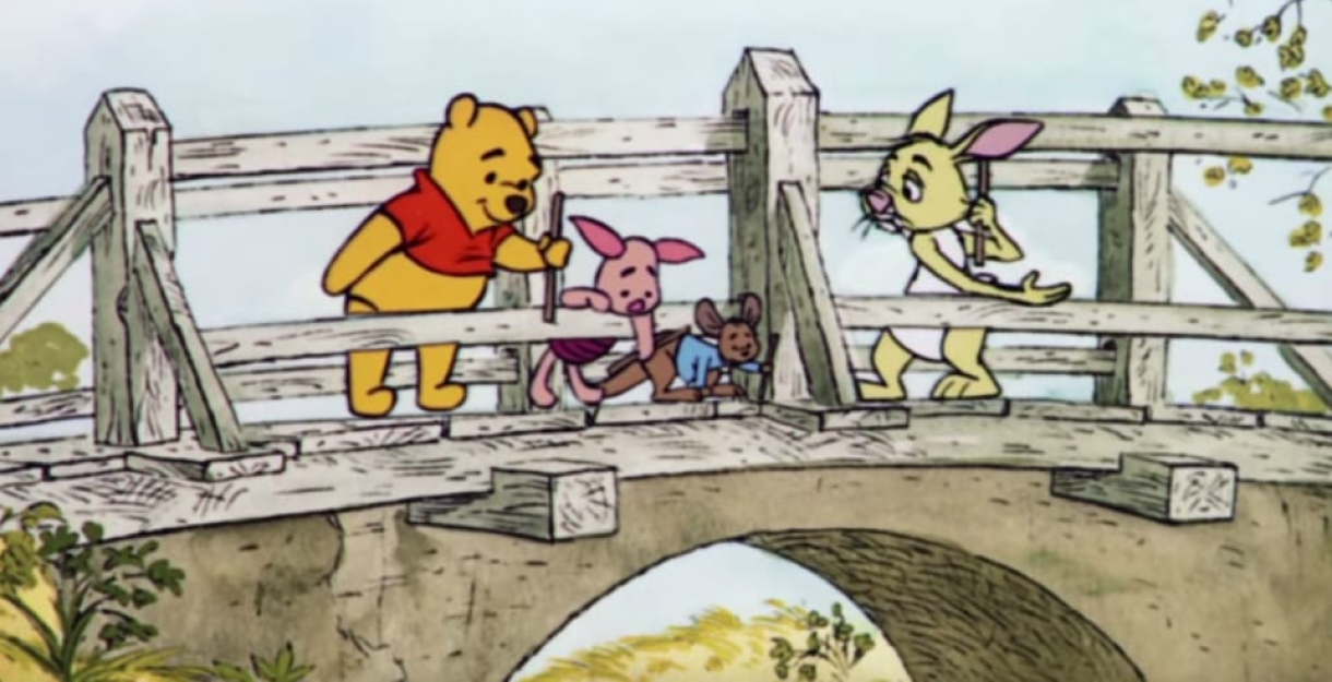 Cartoon image of Winnie the Pooh and friends playing pooh sticks