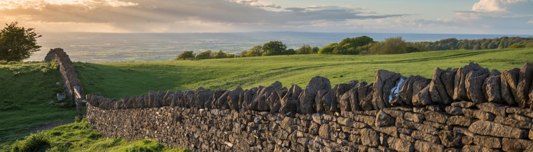 A Cotswold stone wall bordering open countryside