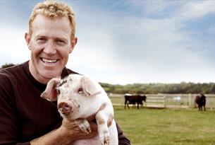 Adam Henson with a piglet at Cotswold Farm Park