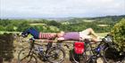 Cyclists resting on a Cotswolds wall